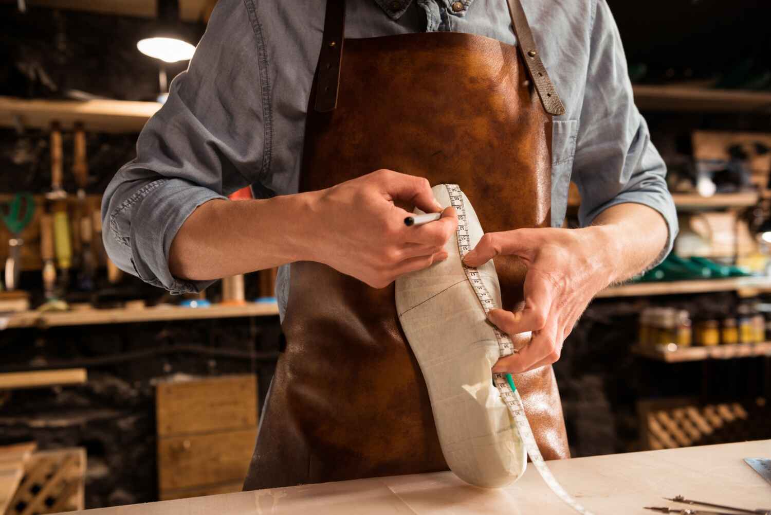 Schoenmaker meet een schoenmal op voor nauwkeurige nubuck reiniging en reparatie
