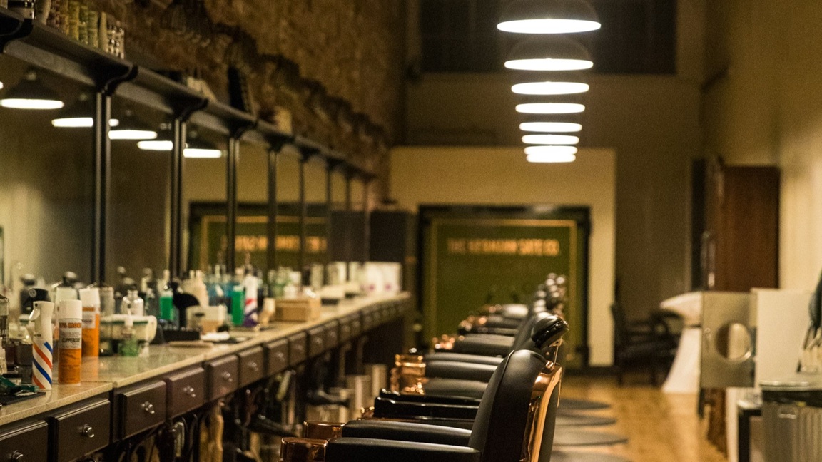 Retro kapsalon met klassieke barberstoelen, houten details en vintage stylingproducten – perfect decor voor retro kapsels.