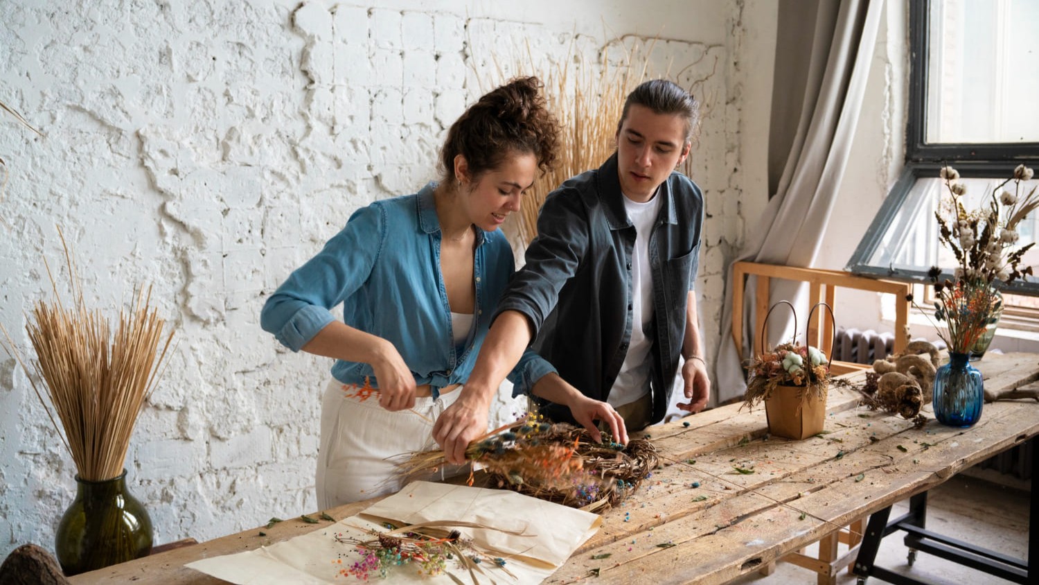 Twee mensen maken winterdecoratie van droogbloemen voor een persoonlijk winter interieur