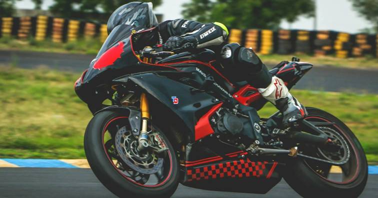 Motorrijder in racehouding op een zwarte en rode sportmotor tijdens een bocht op het circuit