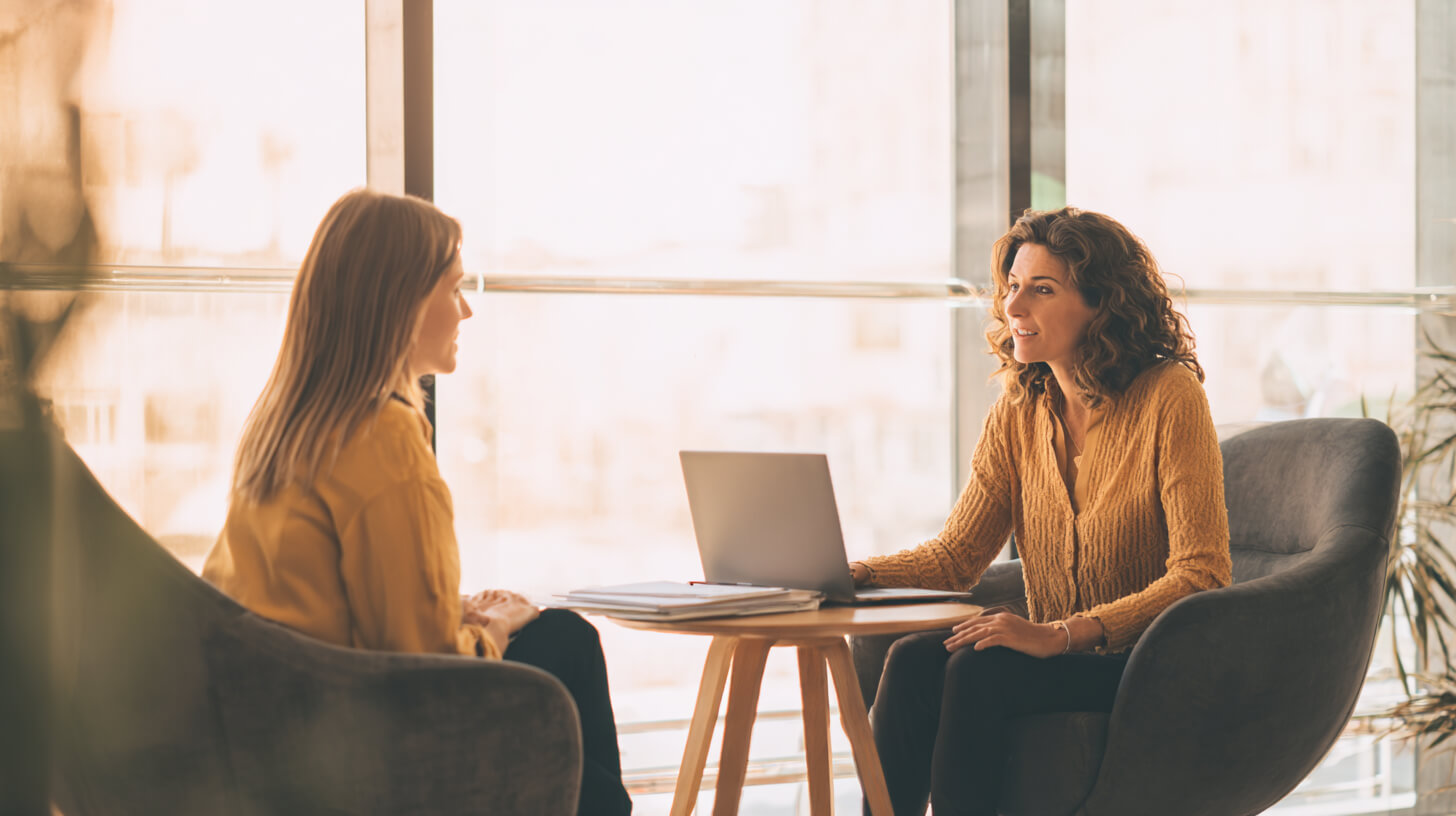 Twee vrouwen bespreken financiën aan tafel tijdens een adviesgesprek over budget en geldzaken